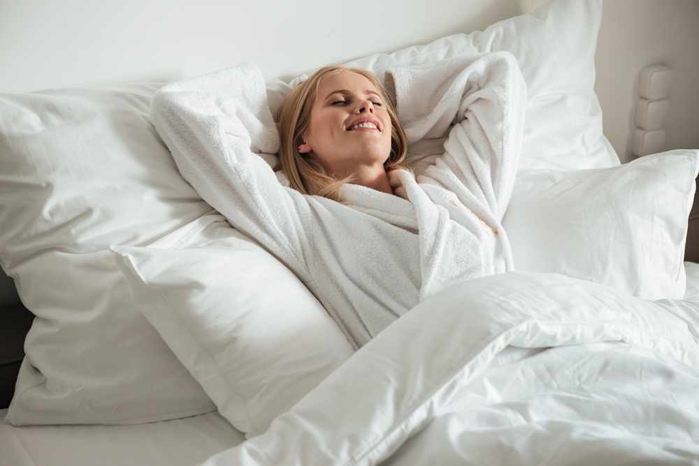 woman-lying-big-bed-down-pillow-duvet.jpg